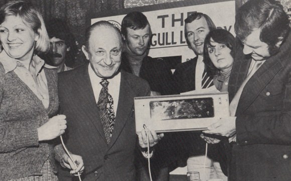 In the 1970s, even the commercial aspect of the game had a certain naive  charm to it, unlike nowadays. The Seagull Lottery is held weekly every Monday at a different venue around the County. The second lottery was held at the Southdown Hotel in Worthing and together with Ron Pavey (commercial manager) and the lottery promoter Joan Shipp are vice-chairman Harry Bloom and players Peter O'Sullivan and Peter Grummitt.