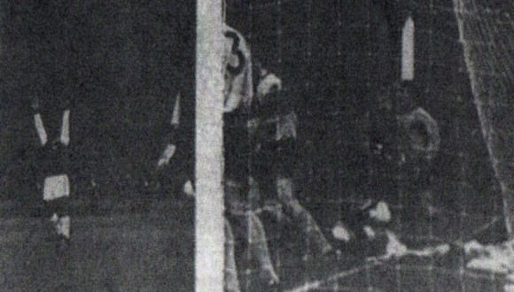 Dawson holds his hands aloft as Gilliver tumbles between the defenders, with ball in the net